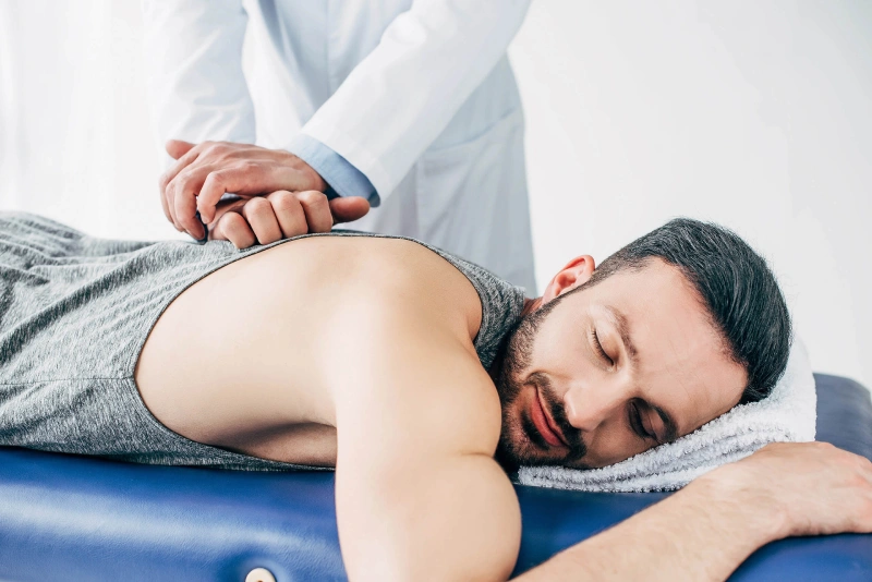 Patient receiving assessment and treatment on therapy table